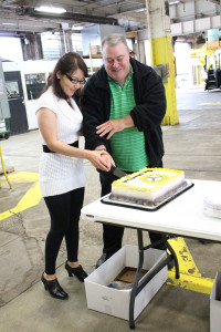 Keith Taylor and his wife, Ganaa, cut their retirement cake and celebrate with employees. 